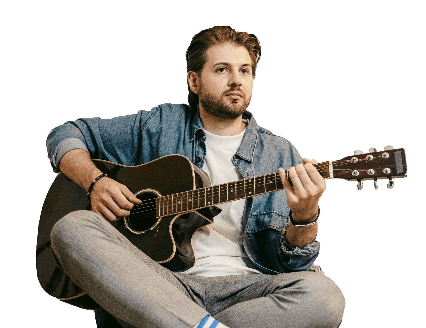 Man playing acoustic guitar, enhancing musical skills.